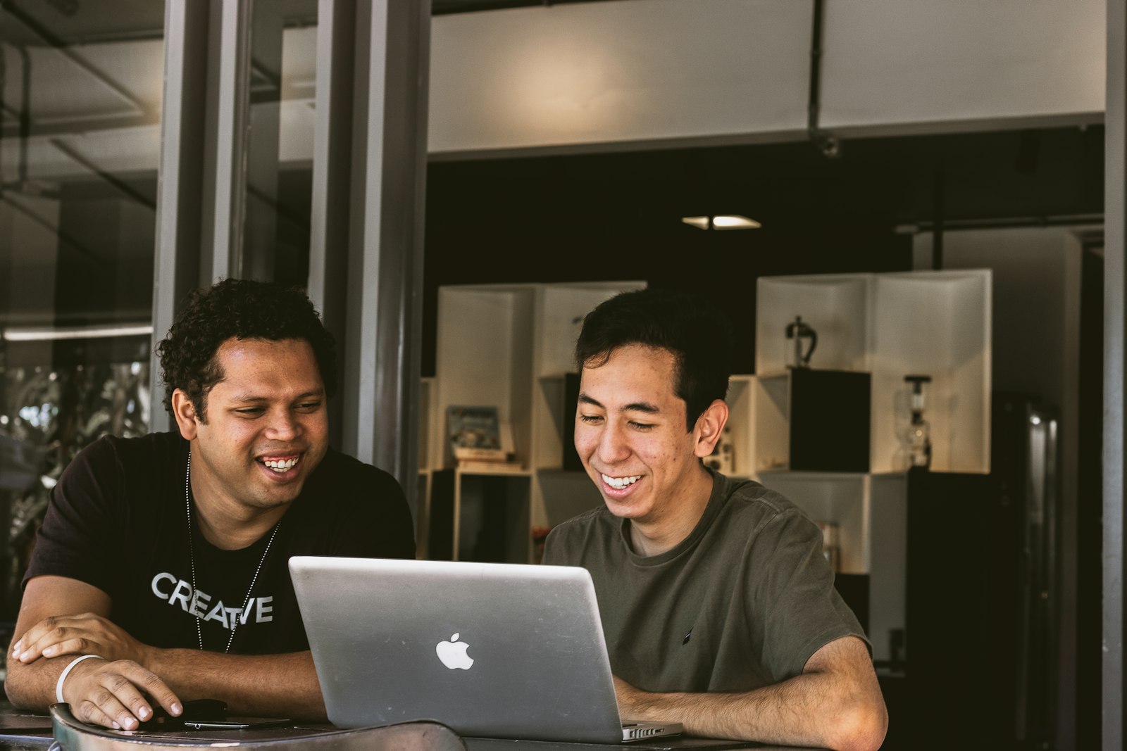 Two colleagues reviewing work together on a laptop